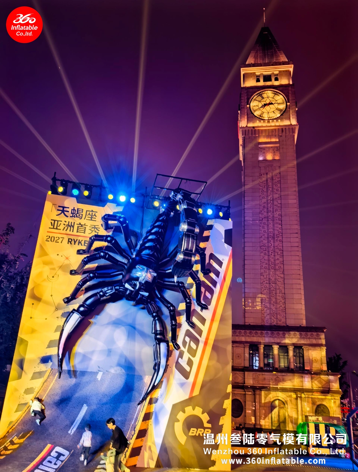 Night view of the mechanical scorpion inflatable by Wenzhou 360 Inflatable alongside a classic clock tower and modern skyscrapers.